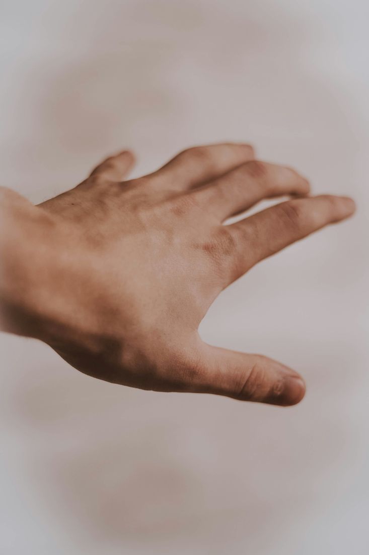 A hand reaching, softly lit