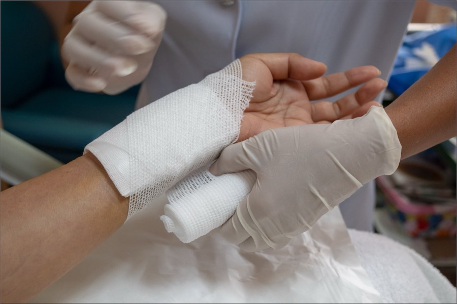 A wound being carefully dressed and bandaged